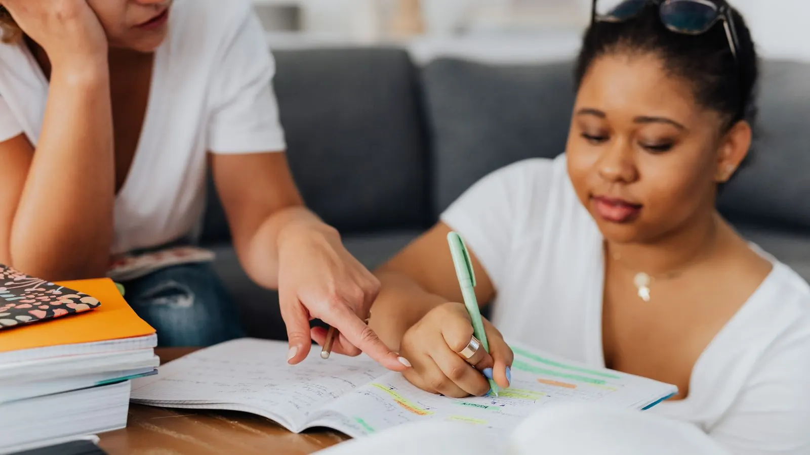 An online student meeting with a tutor over video from a home desk